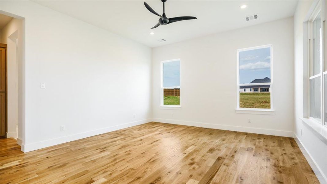 Empty room featuring ceiling fan and light hardwood / wood-style floors