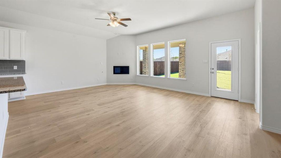 Unfurnished living room featuring light wood-style flooring and ceiling fan