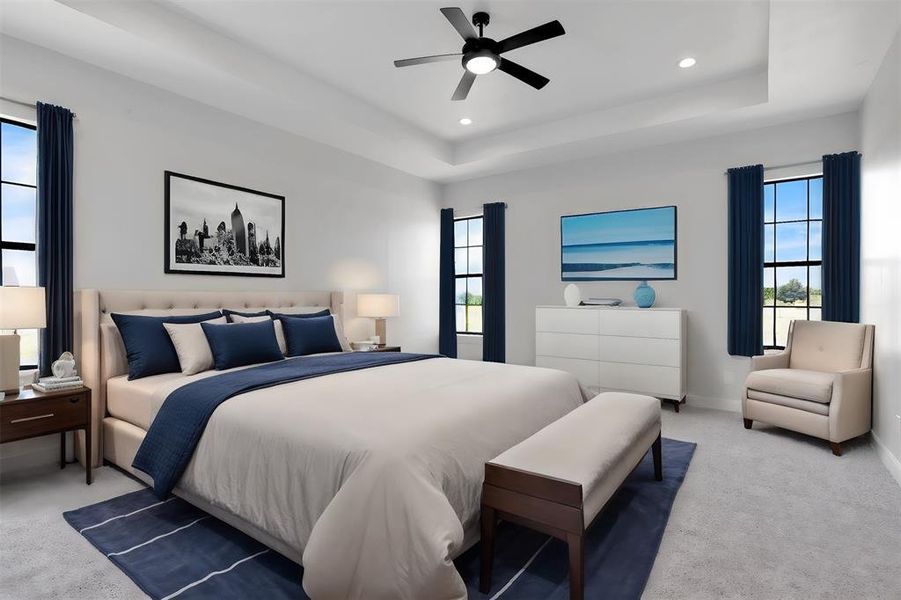 Bedroom featuring a raised ceiling, carpet, multiple windows, and ceiling fan