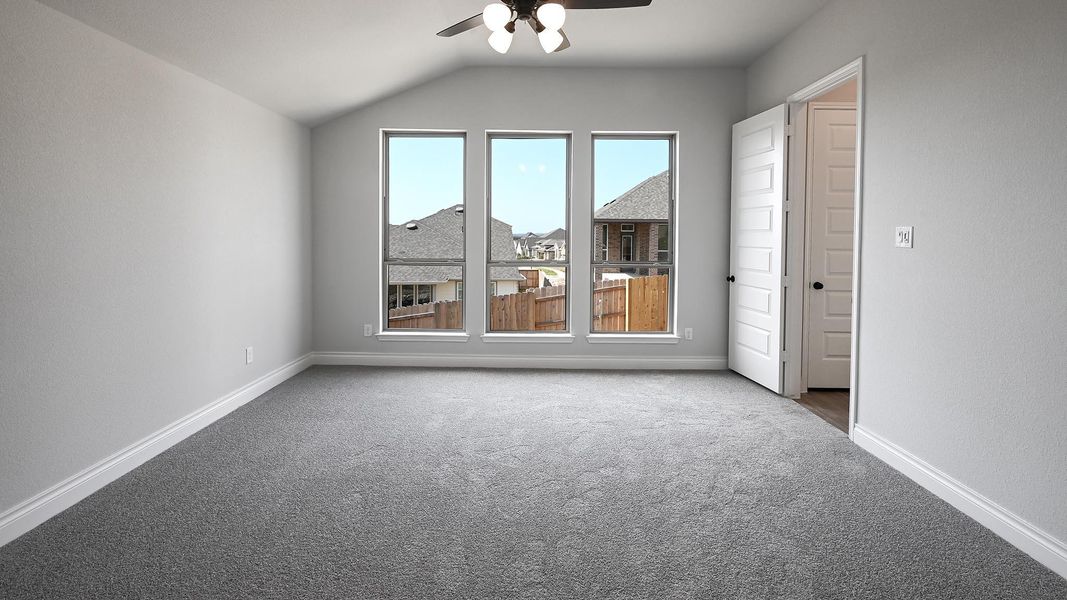 Carpeted spare room featuring baseboards, lofted ceiling, and ceiling fan Carpeted spare room featuring baseboards, lofted ceiling, and ceiling fan