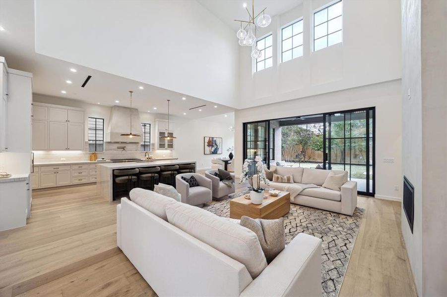 Incredible living room features thoughtful details such as floor plugs, modern fireplace with soaring plaster surround, and beautiful transom windows that allow in even more natural light.