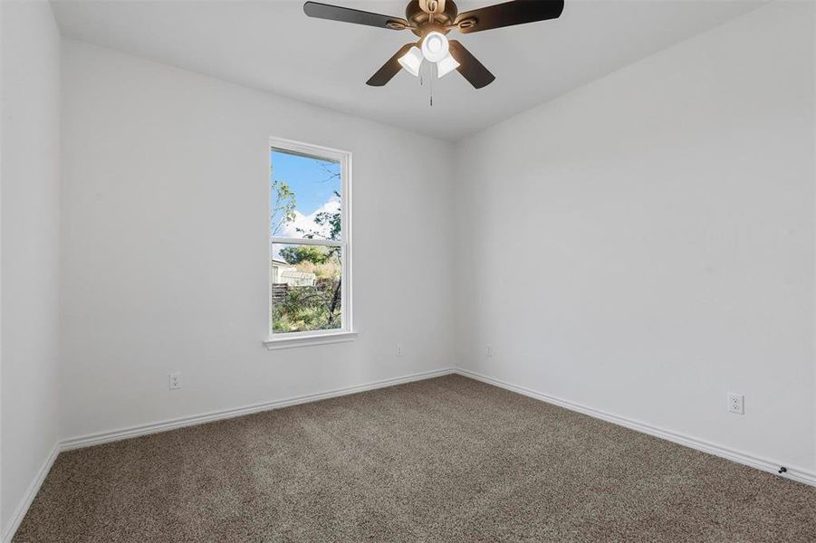 Carpeted spare room featuring ceiling fan