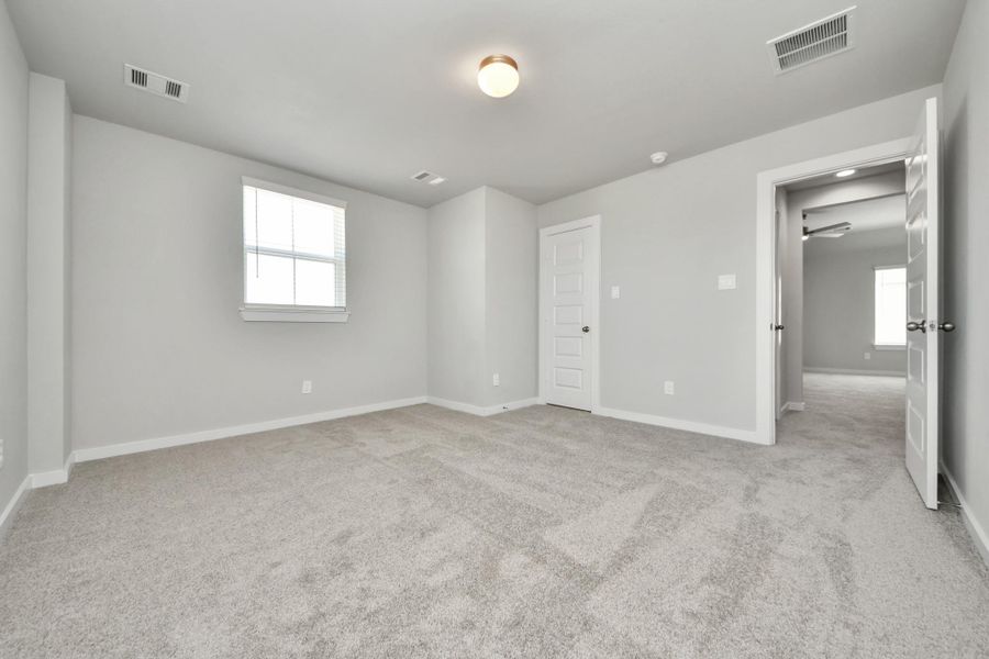 Secondary bedroom features plush carpeting, large windows that let in plenty of natural light, bright paint, and spacious closets. Sample photo of completed home with similar floor plan. Actual colors and selections may vary. Secondary bedroom features plush carpeting, large windows that let in plenty of natural light, bright paint, and spacious closets. Sample photo of completed home with similar floor plan. Actual colors and selections may vary.