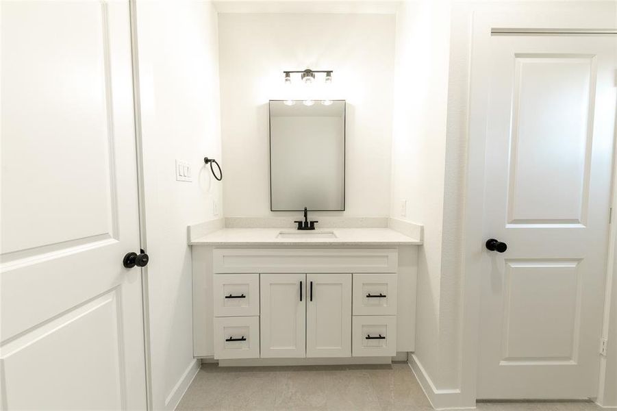 Bathroom with tile patterned floors and vanity