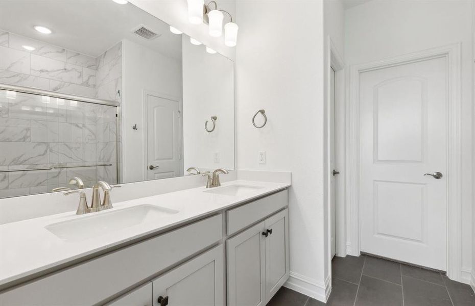 Modern owner's bath with dual vanities and a spacious shower *Real home pictured Modern owner's bath with dual vanities and a spacious shower *Real home pictured