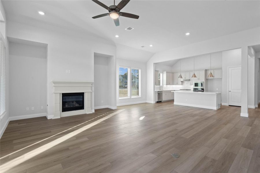 Spacious and light-filled living area showcasing an open layout, neutral tones, and wide plank flooring that enhances the airy feel. Large windows invite natural light, while the seamless connection to the kitchen creates an ideal setting for everyday living and entertaining. Spacious and light-filled living area showcasing an open layout, neutral tones, and wide plank flooring that enhances the airy feel. Large windows invite natural light, while the seamless connection to the kitchen creates an ideal setting for everyday living and entertaining.