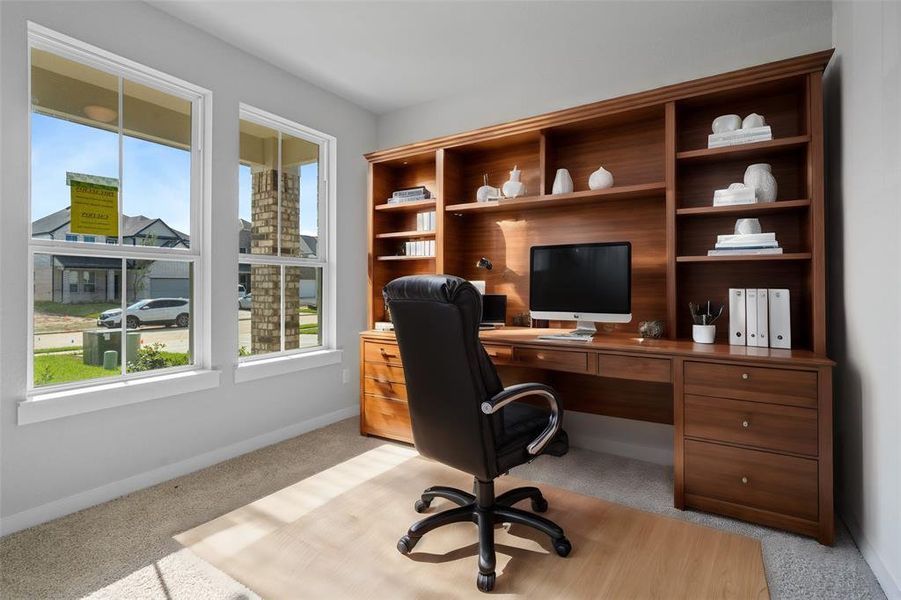 Quietly nestled in front of the home is the handsome home office. Featuring plush carpet flooring, high ceilings, large windows with privacy blinds and custom paint.