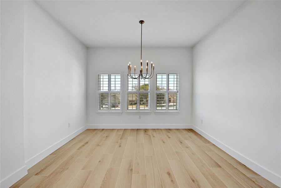 Gorgeous dining room with plenty of natural lighting, a modern chandelier, and plenty of space to host!