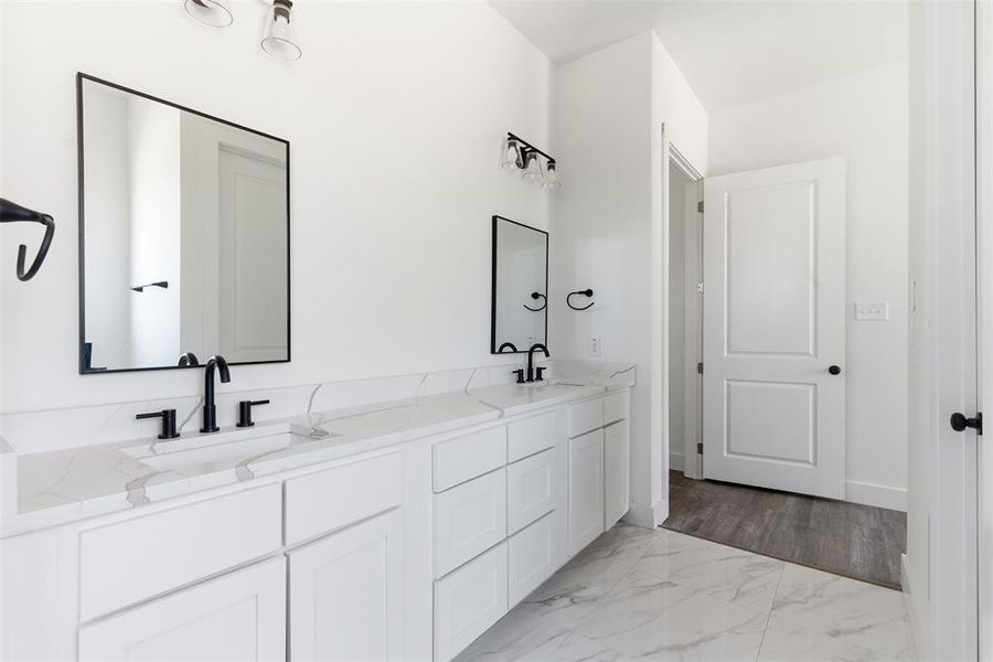 Bathroom with double vanity and light marble finish floors Bathroom with double vanity and light marble finish floors