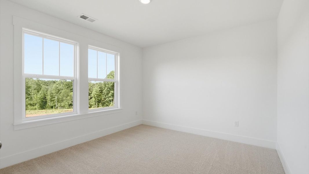 Tasteful bedroom with plush carpet, a walk-in closet, and large windows for abundant natural light at Pinebrook