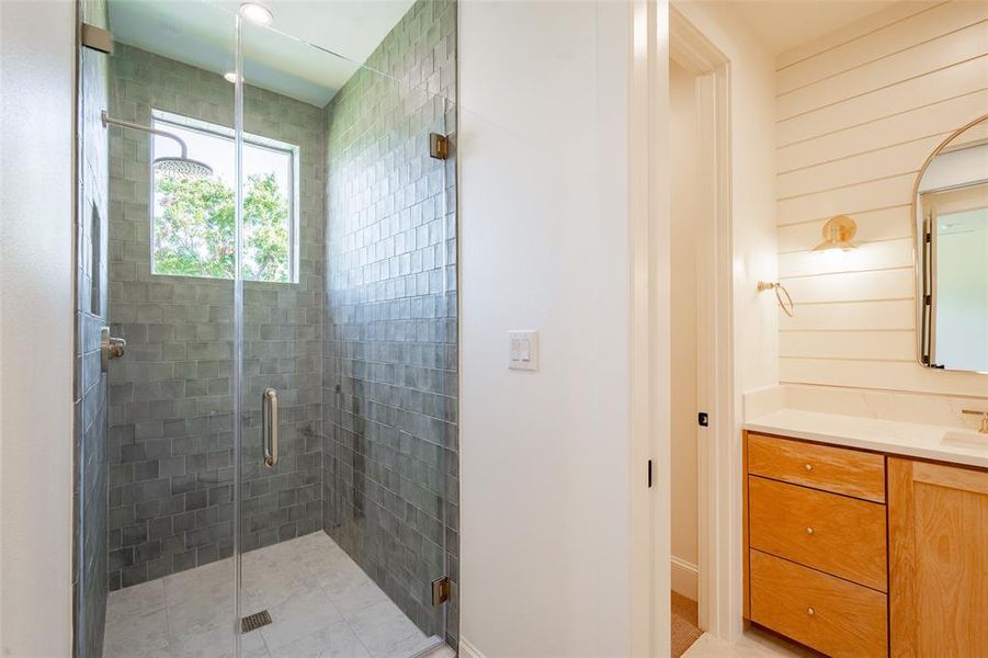 Bathroom with vanity, wooden walls, and an enclosed shower