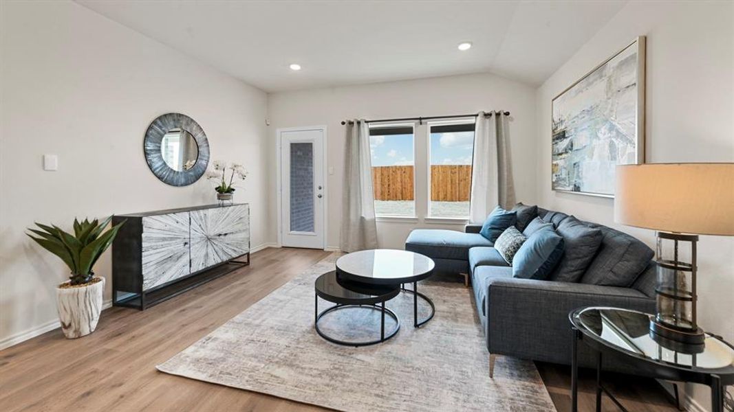 Living room featuring light wood finished floors, recessed lighting, and lofted ceiling Living room featuring light wood finished floors, recessed lighting, and lofted ceiling