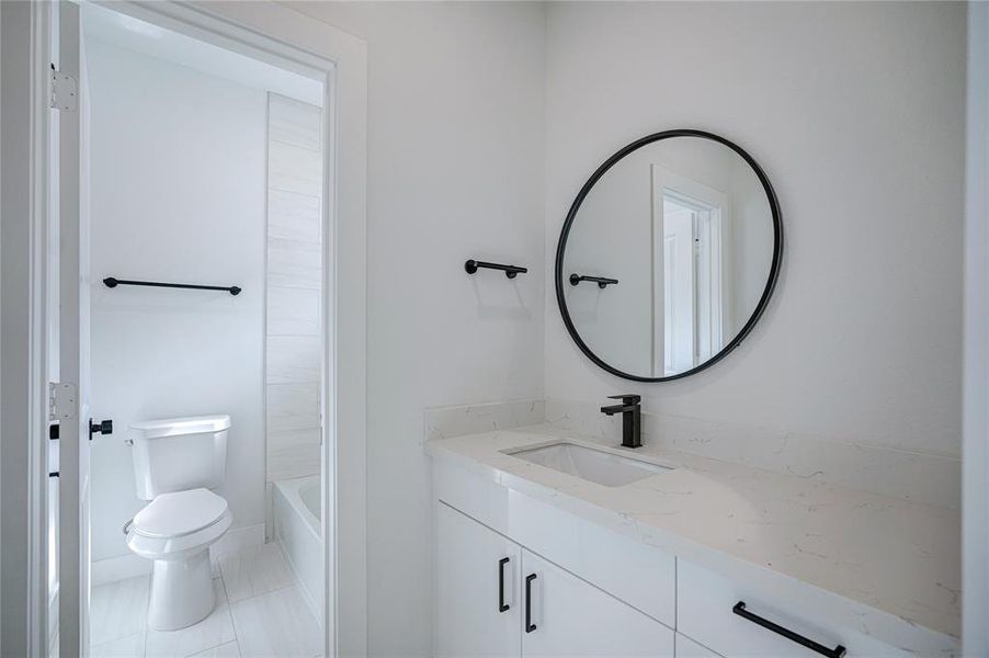 Each secondary bathroom has their own sink and cabinet space