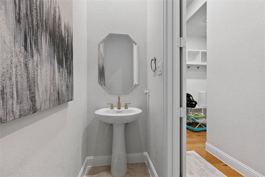 Bathroom with a textured wall and light wood-style floors