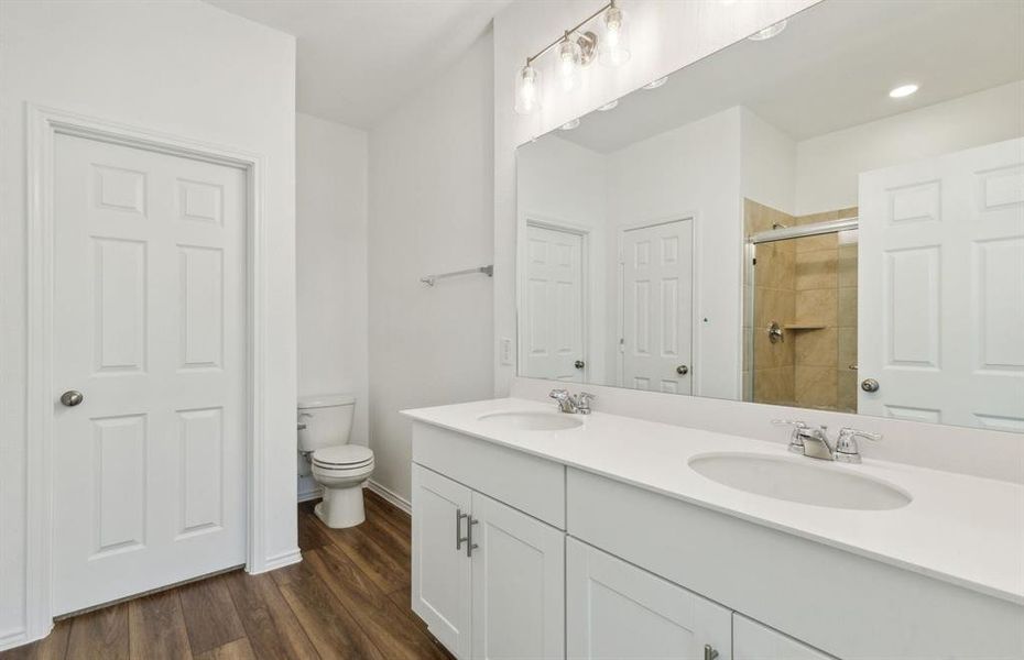 Elegant owner's bathroom with dual vanity and oversized shower*real home pictured