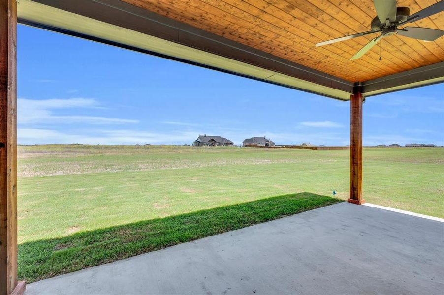 View of yard with a patio, a rural view, and ceiling fan