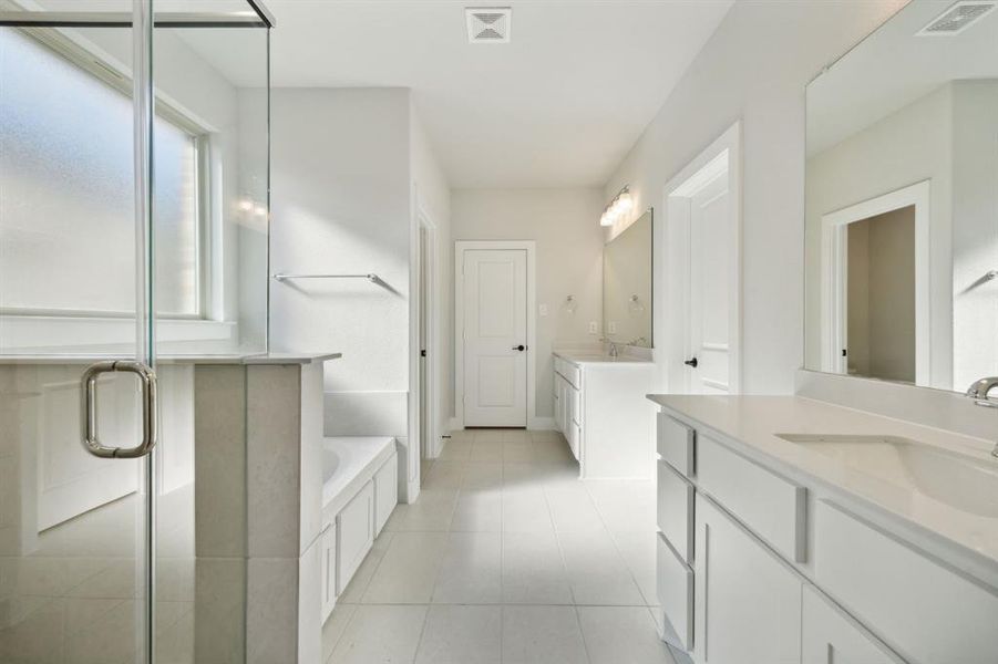 Bathroom featuring separate shower and tub, tile patterned floors, and vanity