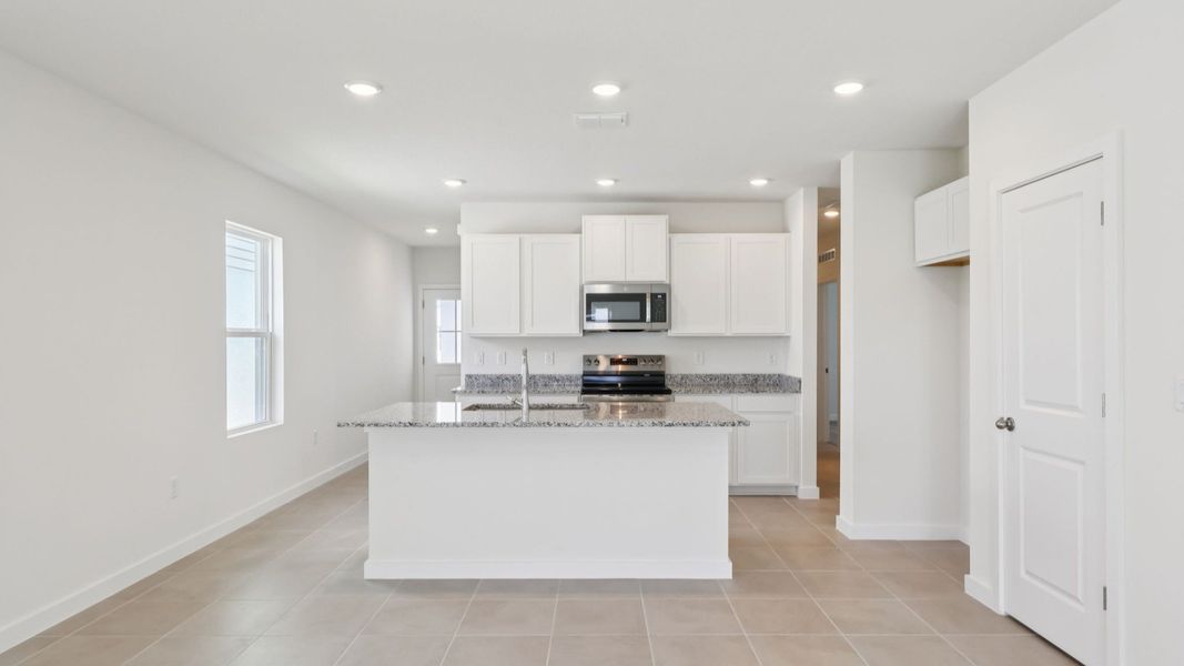 Bright Kitchen with granite Countertops, an Island with dishwasher and ample cabinetry and spacious Pantry