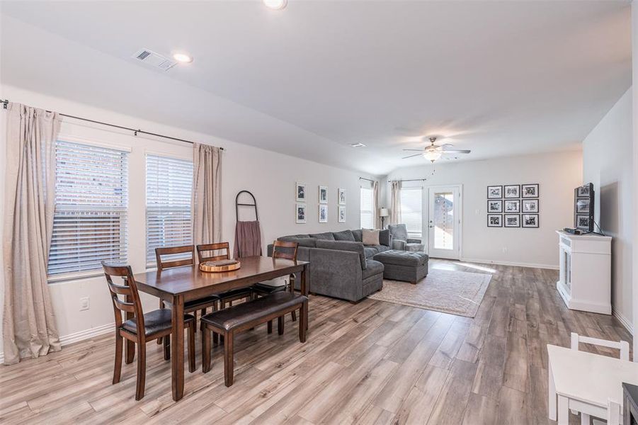 Dining space with light wood finished floors, a ceiling fan, visible vents, and baseboards