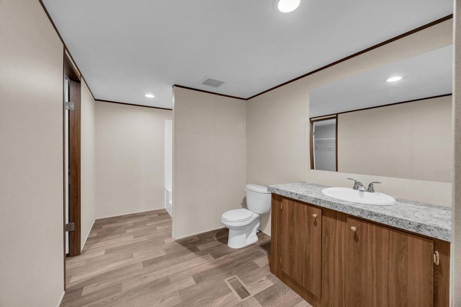 Bathroom with light wood finished floors, vanity, recessed lighting, a bathtub, and crown molding