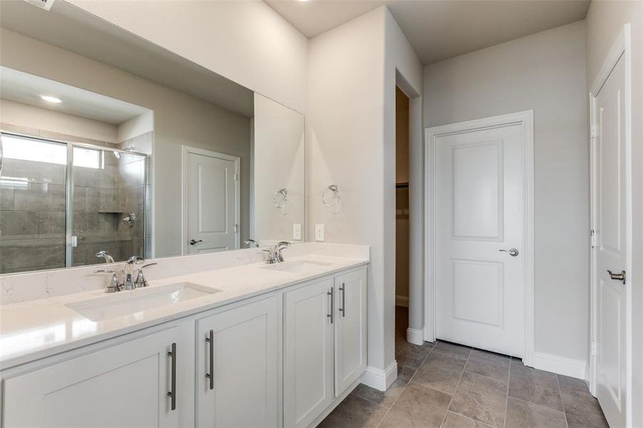 Bathroom featuring an oversized shower, double vanity, and light tile patterned floors