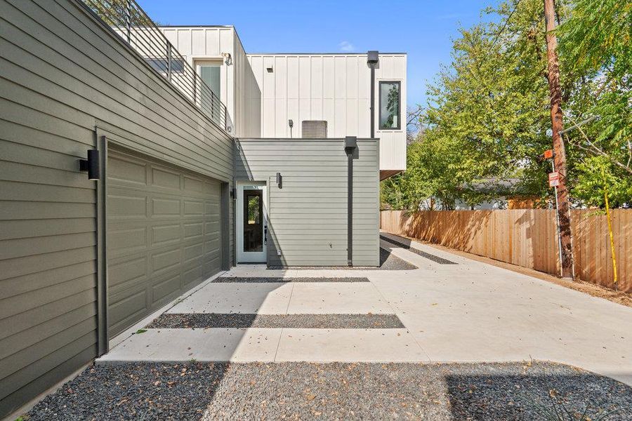 Rear view of property with a garage, board and batten siding, and a patio