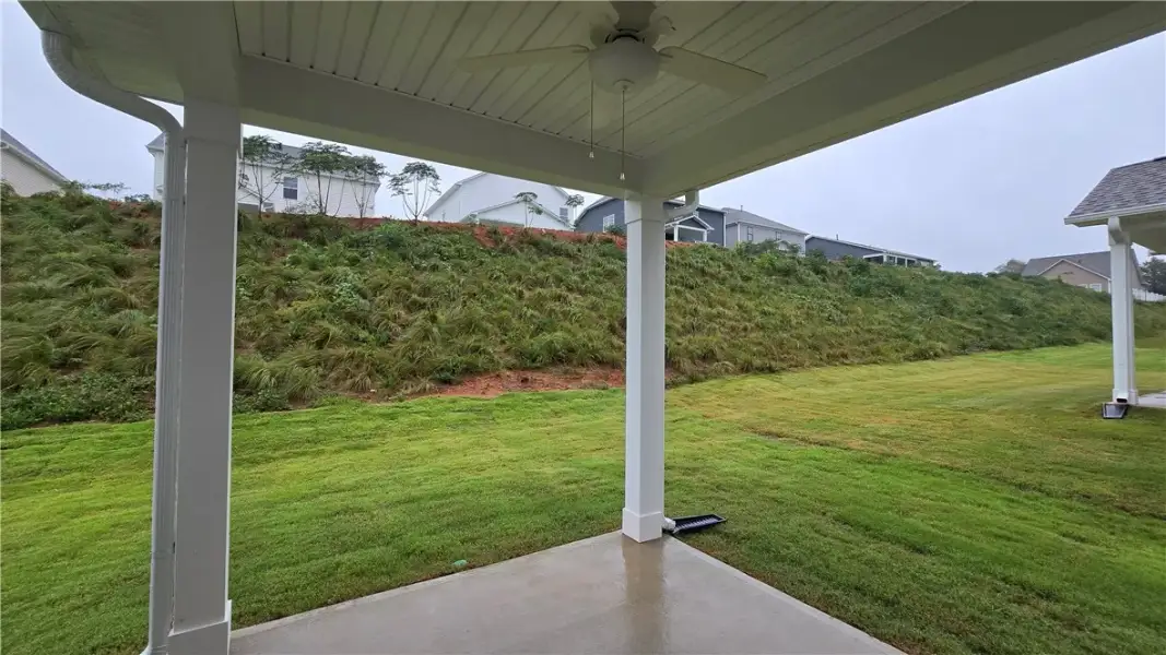 A sheltered back porch looks out over a grassy yar
