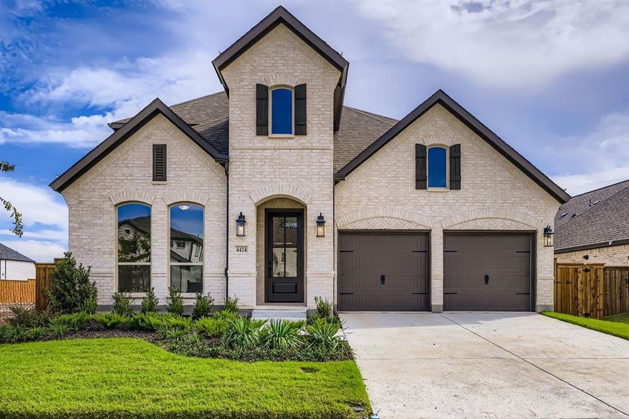 French country home with brick siding, concrete driveway, a garage, and a shingled roof French country home with brick siding, concrete driveway, a garage, and a shingled roof