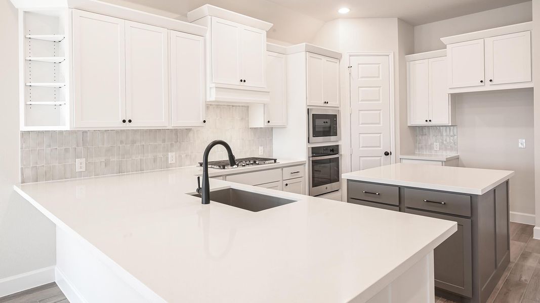 Kitchen with backsplash, white cabinets, a kitchen island, light wood-style floors, and recessed lighting