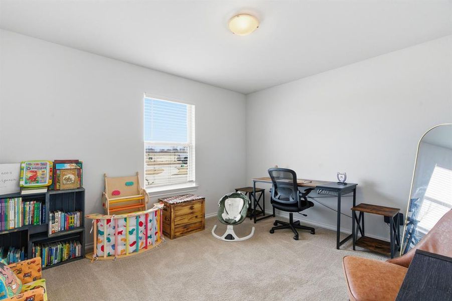Home office featuring light colored carpet and baseboards