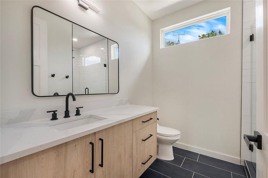 Bathroom featuring vanity, toilet, and tile patterned floors