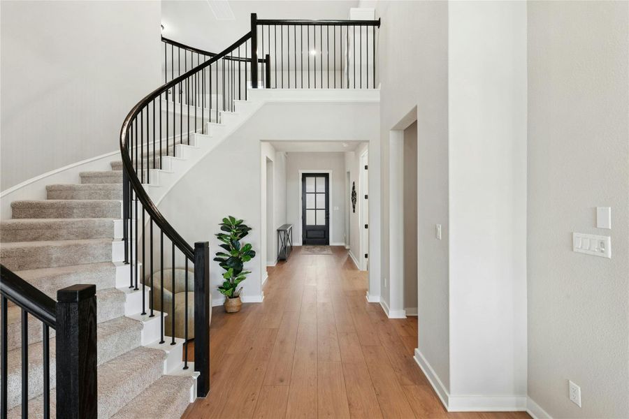 Entrance foyer featuring a high ceiling and light wood-style flooring