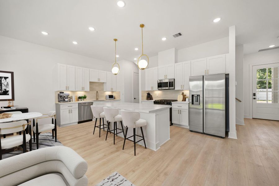 This stunning kitchen displays such a beautiful contrast with white cabinets, neutral paint, quartz countertops, light modern backsplash, and SS appliances, quartz kitchen island with extra storage, breakfast bar, recessed lighting, high ceilings and pantry. This stunning kitchen displays such a beautiful contrast with white cabinets, neutral paint, quartz countertops, light modern backsplash, and SS appliances, quartz kitchen island with extra storage, breakfast bar, recessed lighting, high ceilings and pantry.