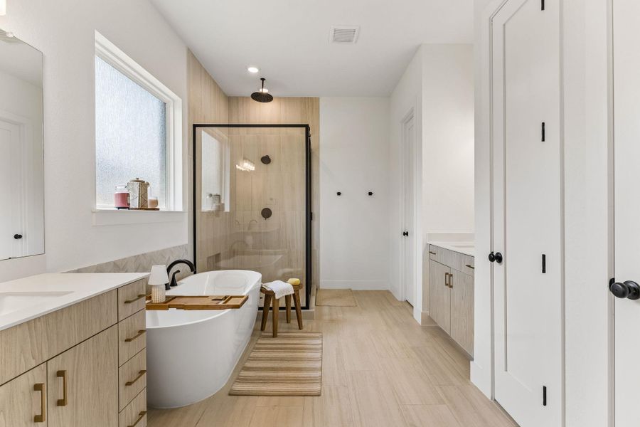 An elegant soaking tub highlights this contemporary master bath with a walk-in shower.