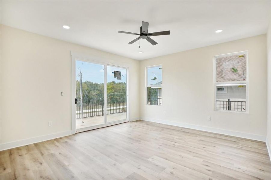 Empty room with ceiling fan and light hardwood / wood-style flooring