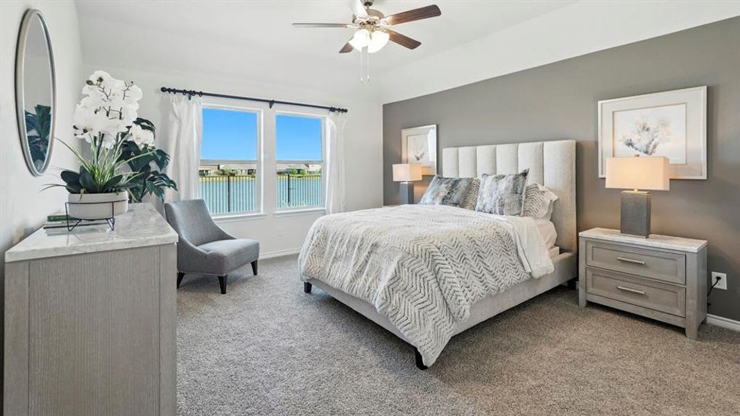 Bedroom featuring light carpet, a ceiling fan, and a water view