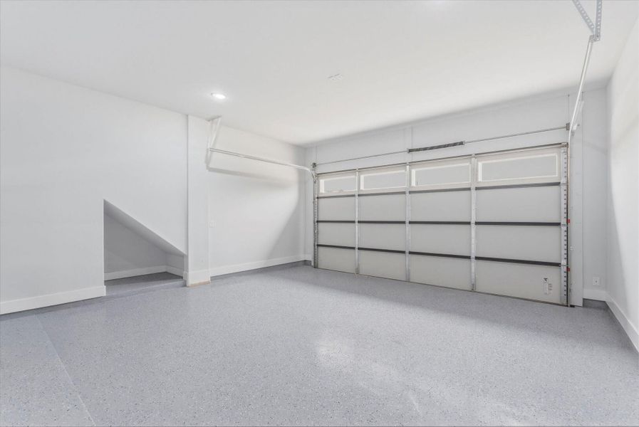 The garage offers an 8-foot door, epoxy-coated flooring, full insulation, and a 220-volt outlet for electric vehicle charging.