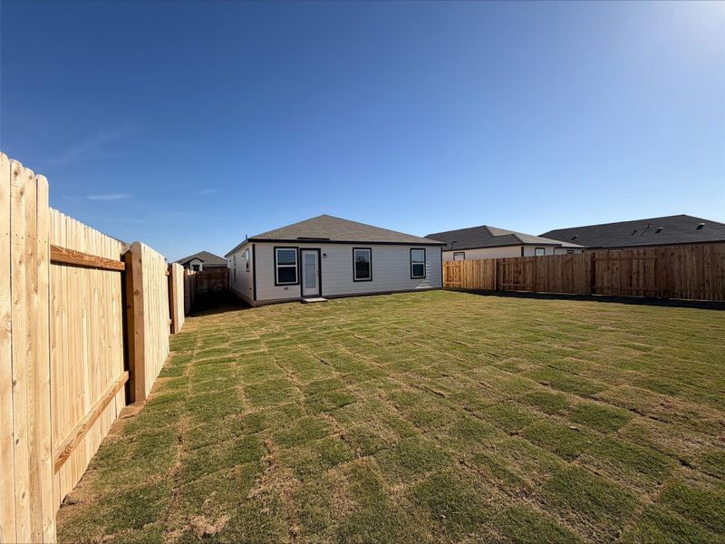 Back of house with a fenced backyard