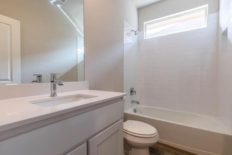 Full bath featuring bathtub / shower combination, vanity, and dark wood-type flooring Full bath featuring bathtub / shower combination, vanity, and dark wood-type flooring