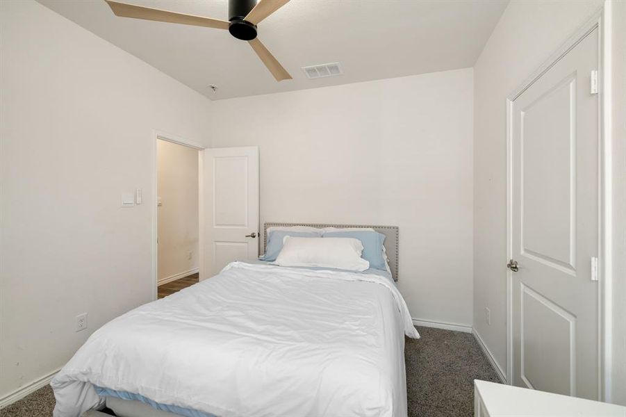 Bedroom featuring dark colored carpet and ceiling fan Bedroom featuring dark colored carpet and ceiling fan