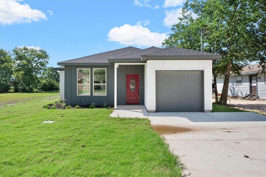 View of front of home featuring a garage and a front yard