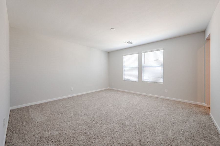 A room with a carpet and windows.