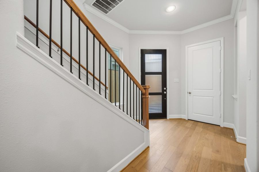Hello, modern welcome moment! This entry sets the tone with warm wood tones, a statement staircase, and access to a coat closet and powder room. Hello, modern welcome moment! This entry sets the tone with warm wood tones, a statement staircase, and access to a coat closet and powder room.