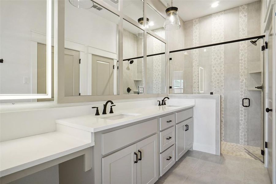 Bathroom featuring tile patterned flooring, vanity, and a shower with shower door