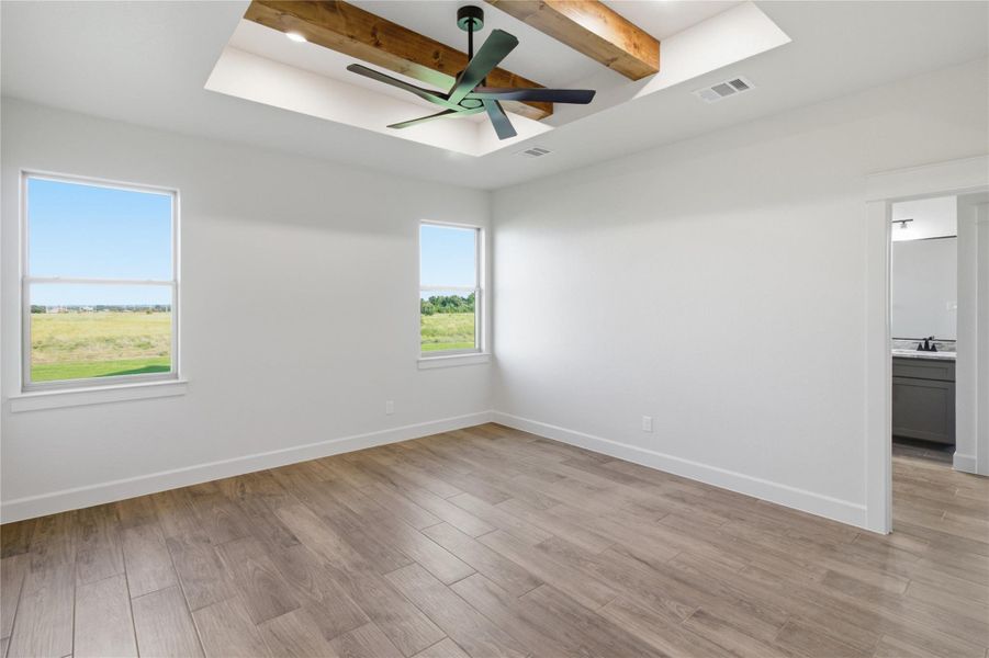 A spacious chamber with a vaulted wood-beamed ceiling and generous window views. A spacious chamber with a vaulted wood-beamed ceiling and generous window views.