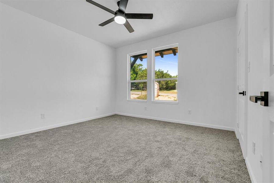 Empty room with ceiling fan and carpet flooring