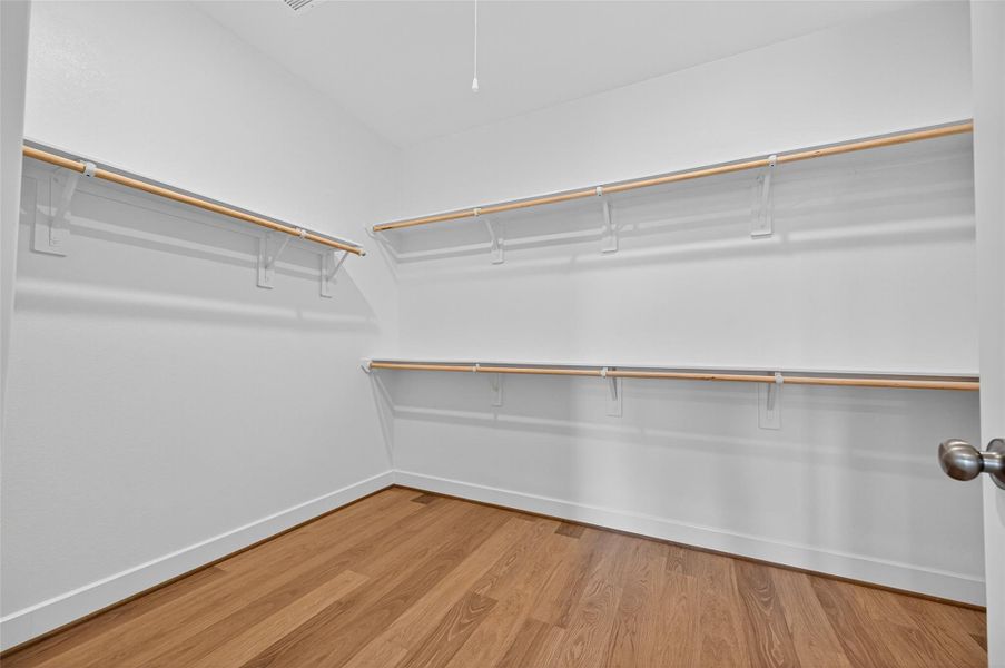 The primary closet offers generous space with double hanging rods for easy organization. Its open layout and clean design make it both practical and inviting.