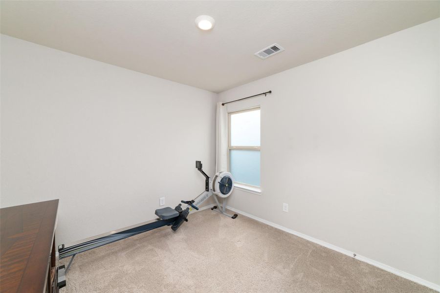 Bedroom with a window that brings in natural light, offering a bright space perfect for a home office, gym, or guest room.