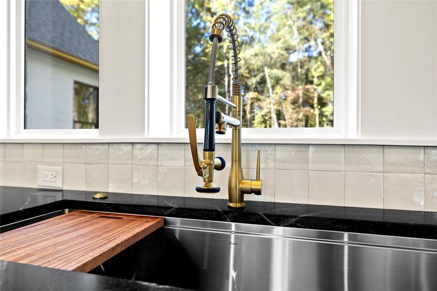 Kitchen view of tasteful backsplash and dark stone countertops