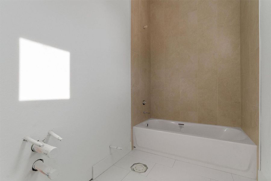 Bathroom featuring tile patterned floors and shower / bath combination Bathroom featuring tile patterned floors and shower / bath combination